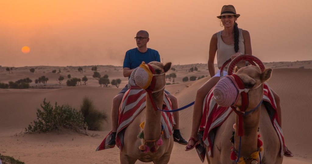 Teenagers enjoying camel ride on Dubai desert safari