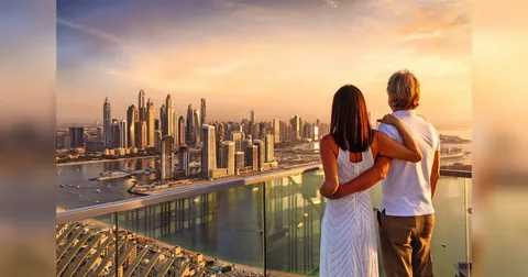 couple watching sunset on Dubai red dunes